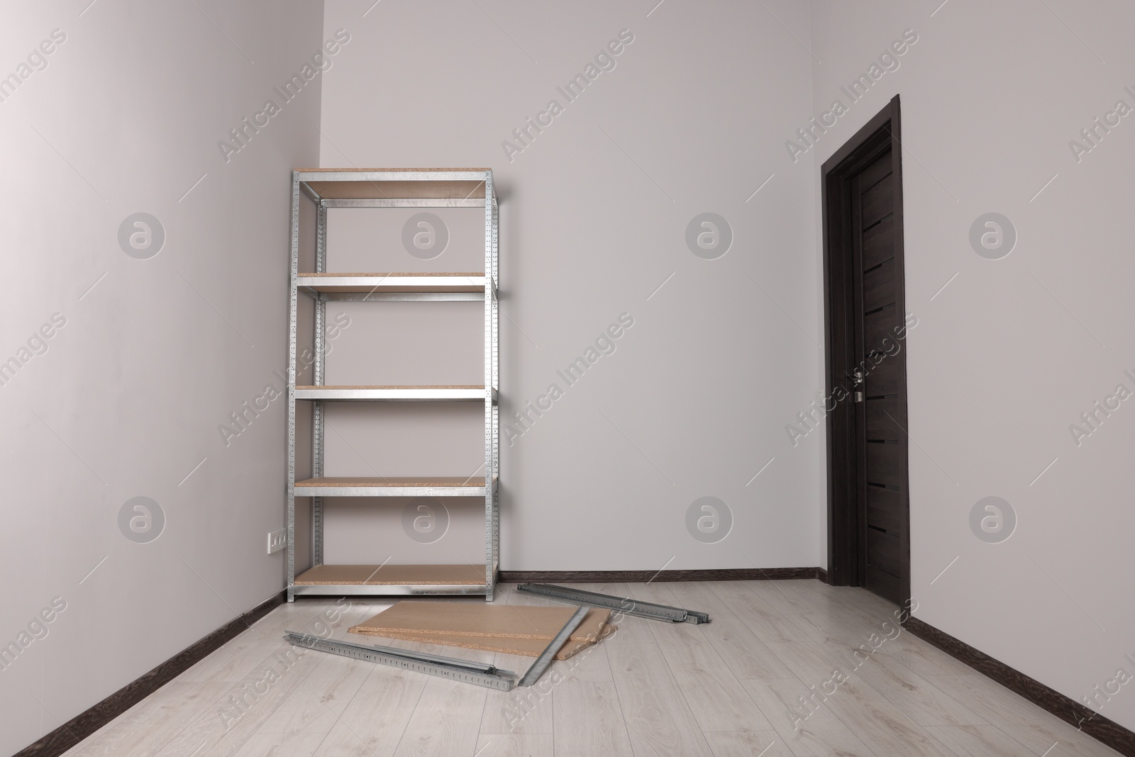 Photo of Office room with white walls and metal storage shelf