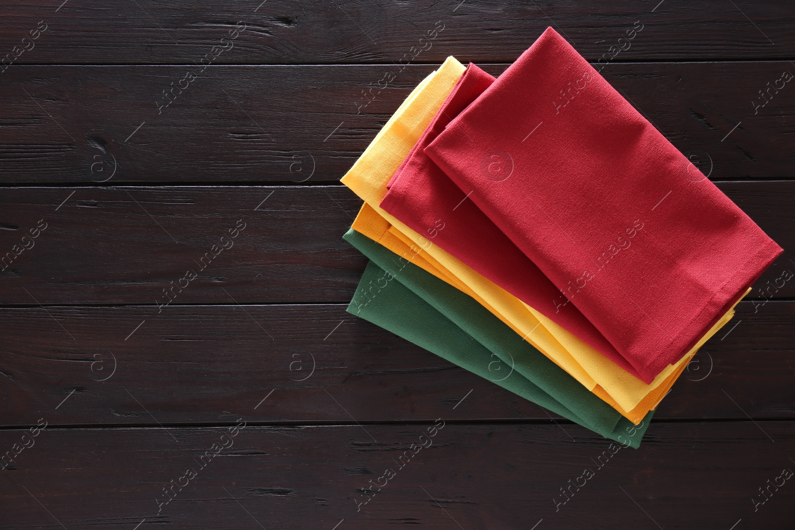 Photo of Different colorful napkins on wooden table, top view. Space for text