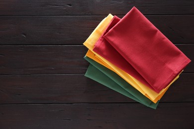 Different colorful napkins on wooden table, top view. Space for text