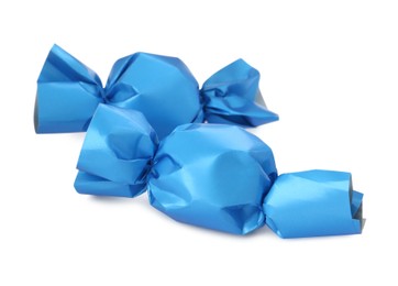 Photo of Delicious candies in light blue wrappers isolated on white