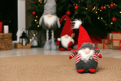 Cute Christmas gnome on floor and festive decor at home. Space for text