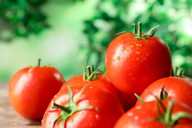 Fresh ripe tomatoes on wooden table, closeup