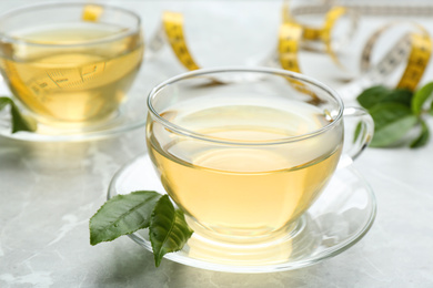 Photo of Herbal diet tea and measuring tape on light table