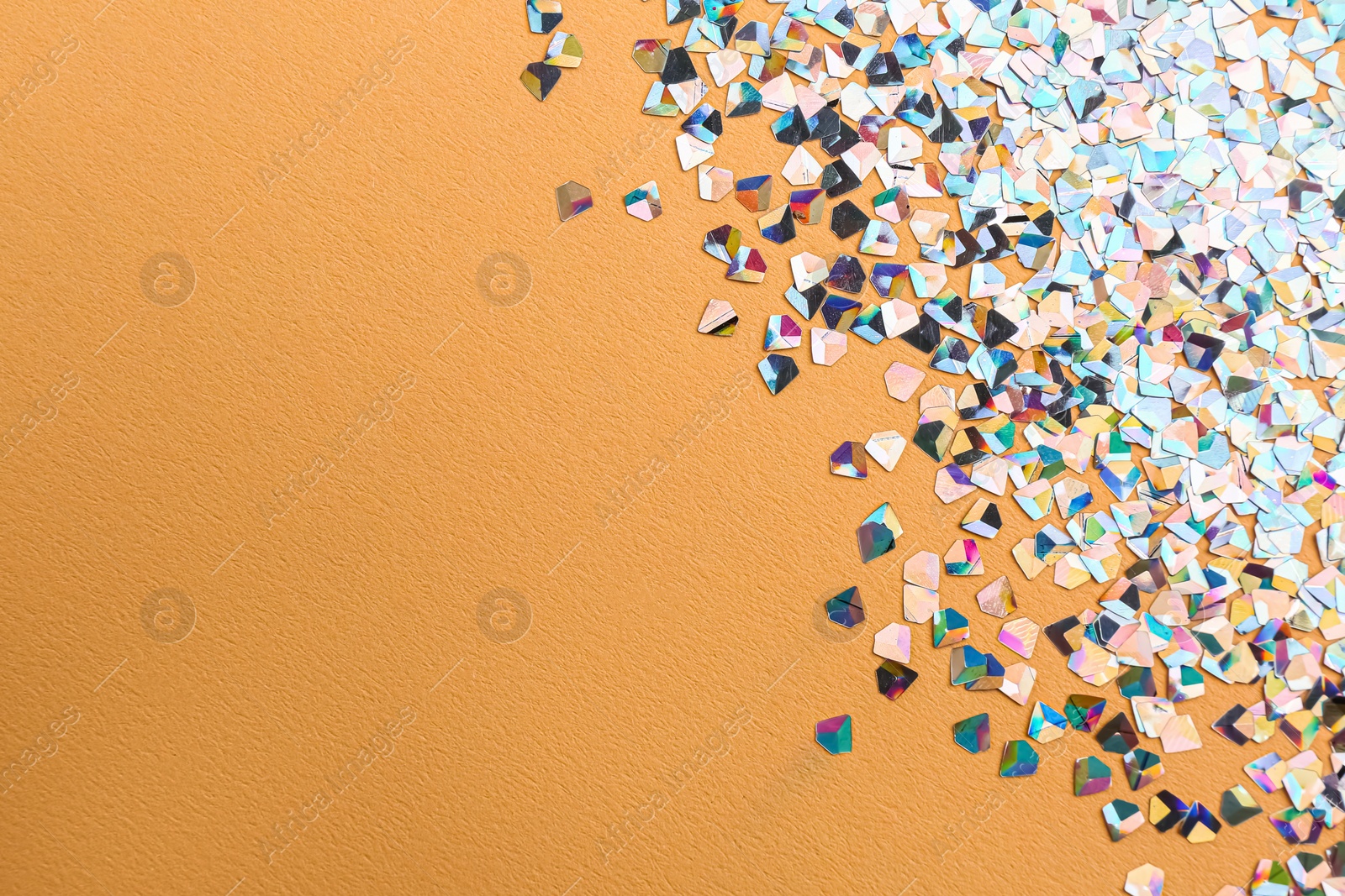 Photo of Shiny bright glitter on beige background. Space for text