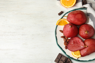 Image of Delicious mulled wine poached pears served on white wooden table, flat lay. Space for text