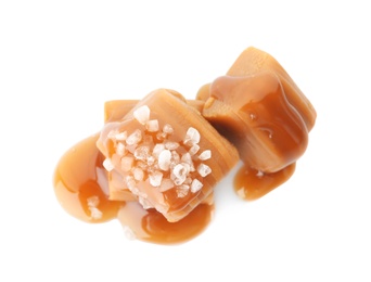 Photo of Delicious candies with caramel sauce and salt on white background