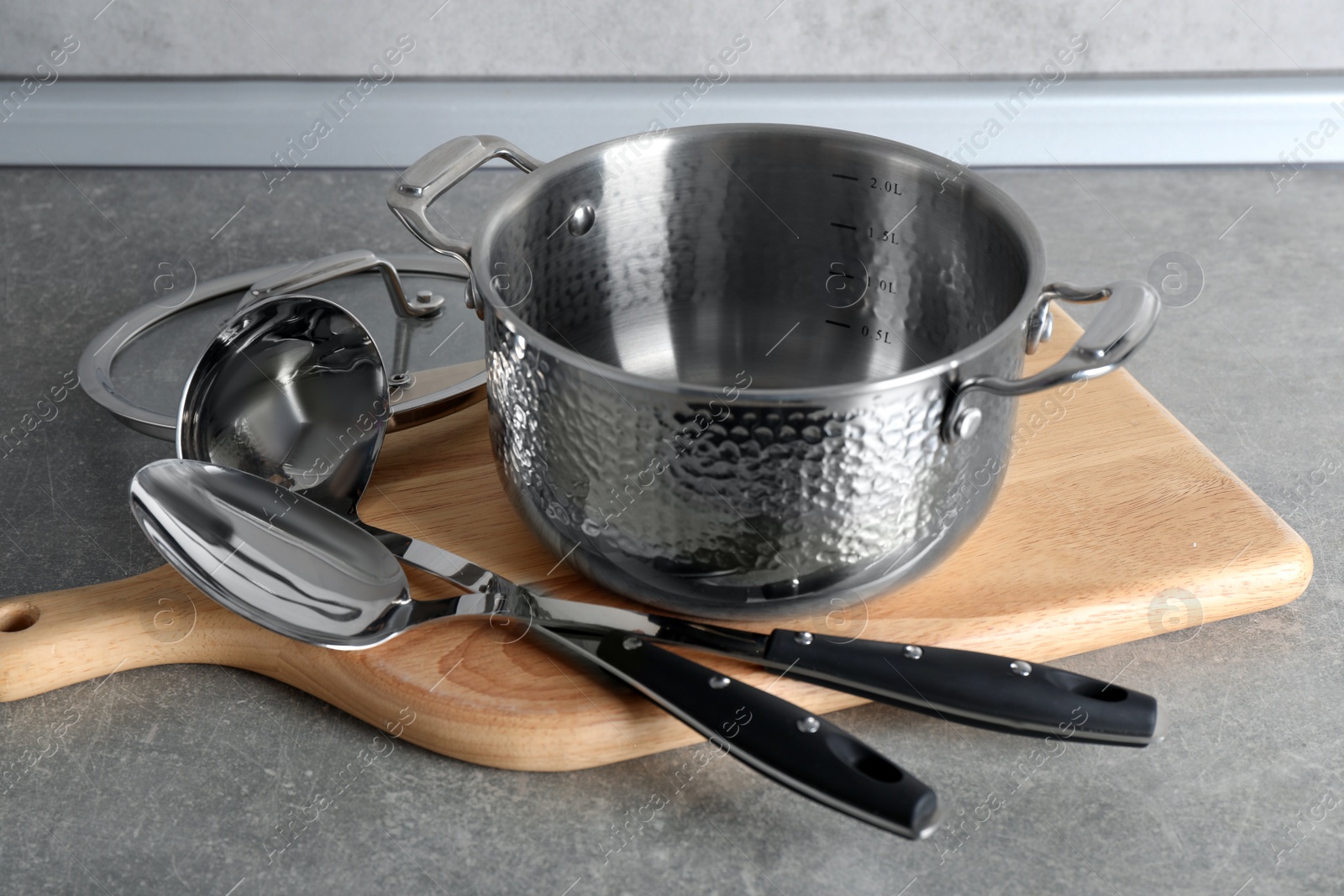 Photo of Set of different cooking utensils on grey countertop in kitchen