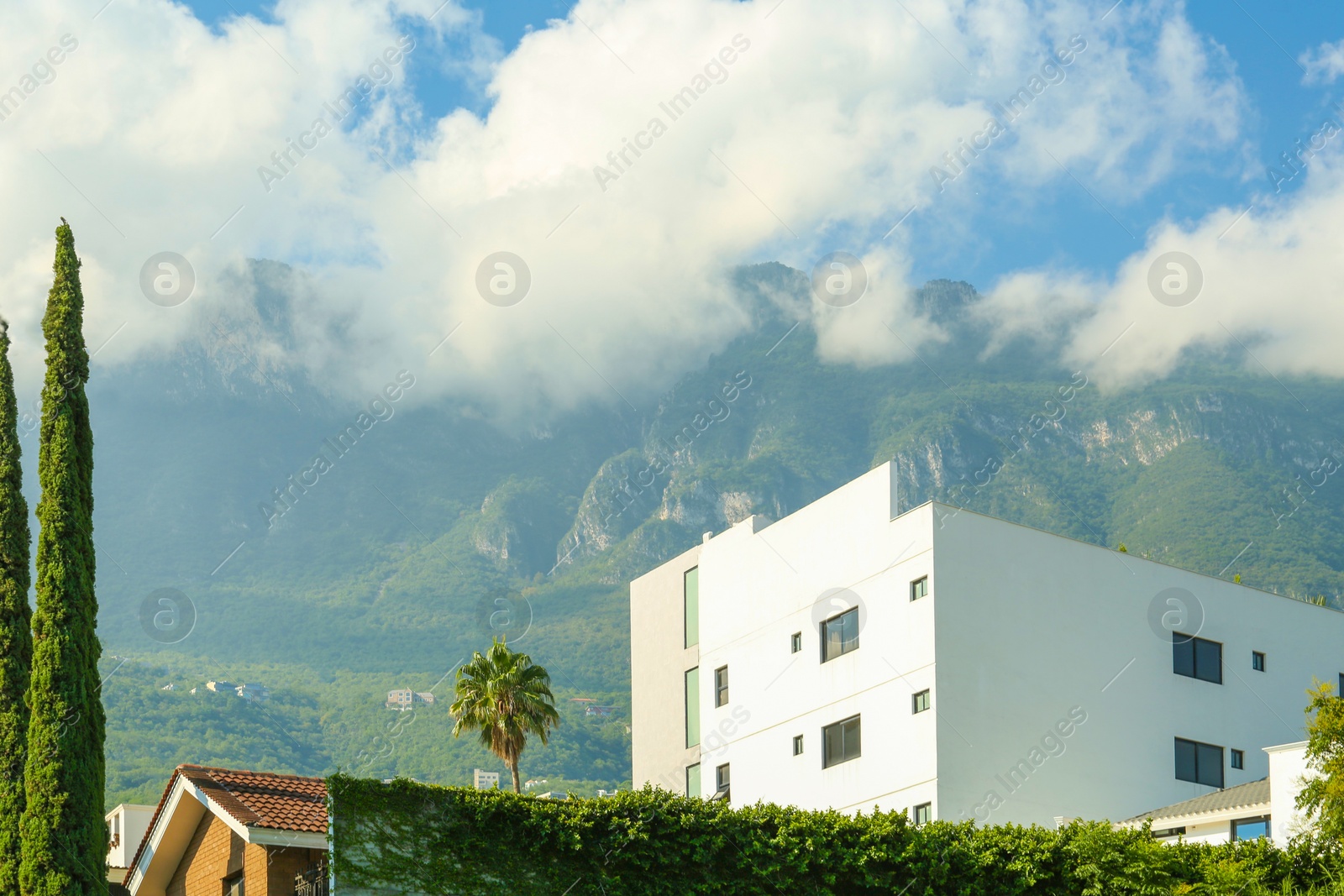 Photo of Beautiful view of building near mountains under cloudy sky