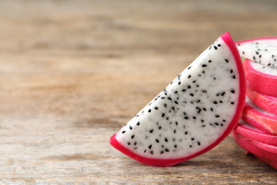 Photo of Slices of delicious dragon fruit (pitahaya) on wooden table, closeup. Space for text