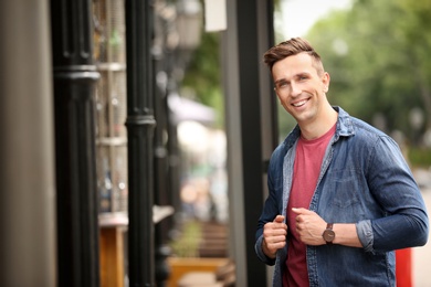 Photo of Portrait of attractive young man in stylish outfit outdoors