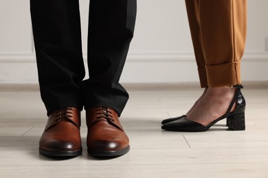 Businessman and businesswoman in elegant shoes indoors, closeup