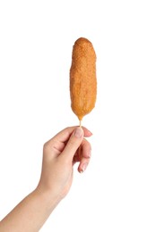 Woman holding delicious deep fried corn dog on white background, closeup