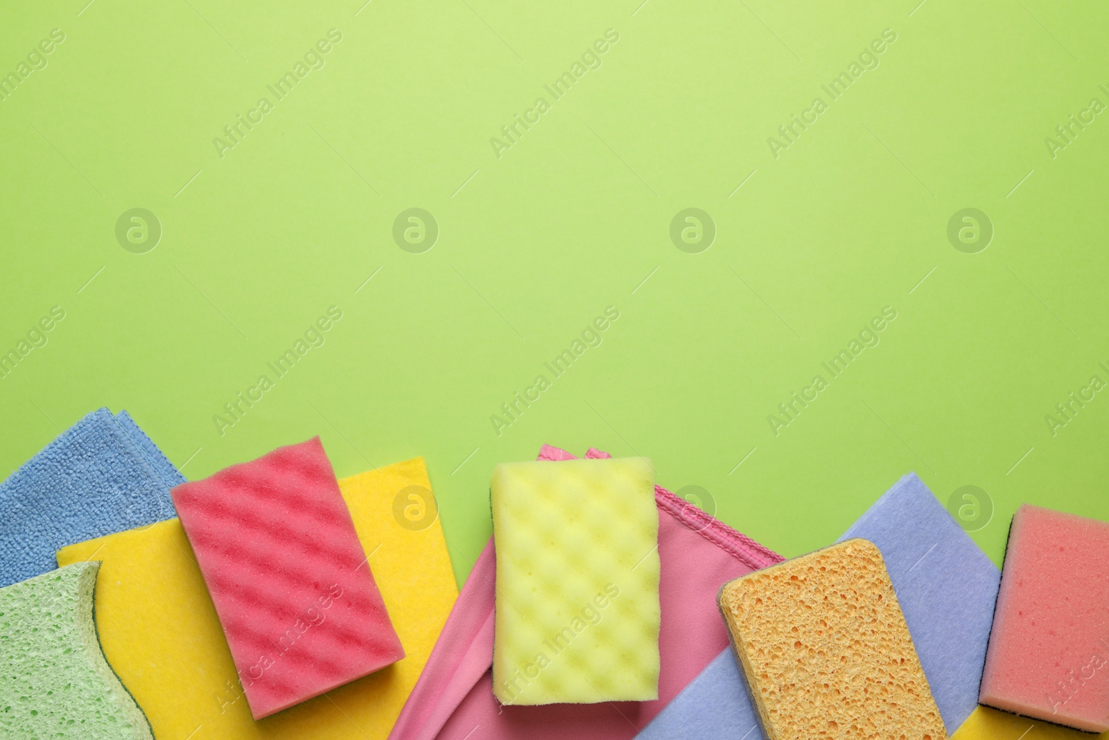 Photo of Flat lay composition with sponges on green background. Space for text