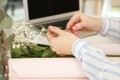 Photo of Woman making bouquet following online florist course at home, closeup. Time for hobby