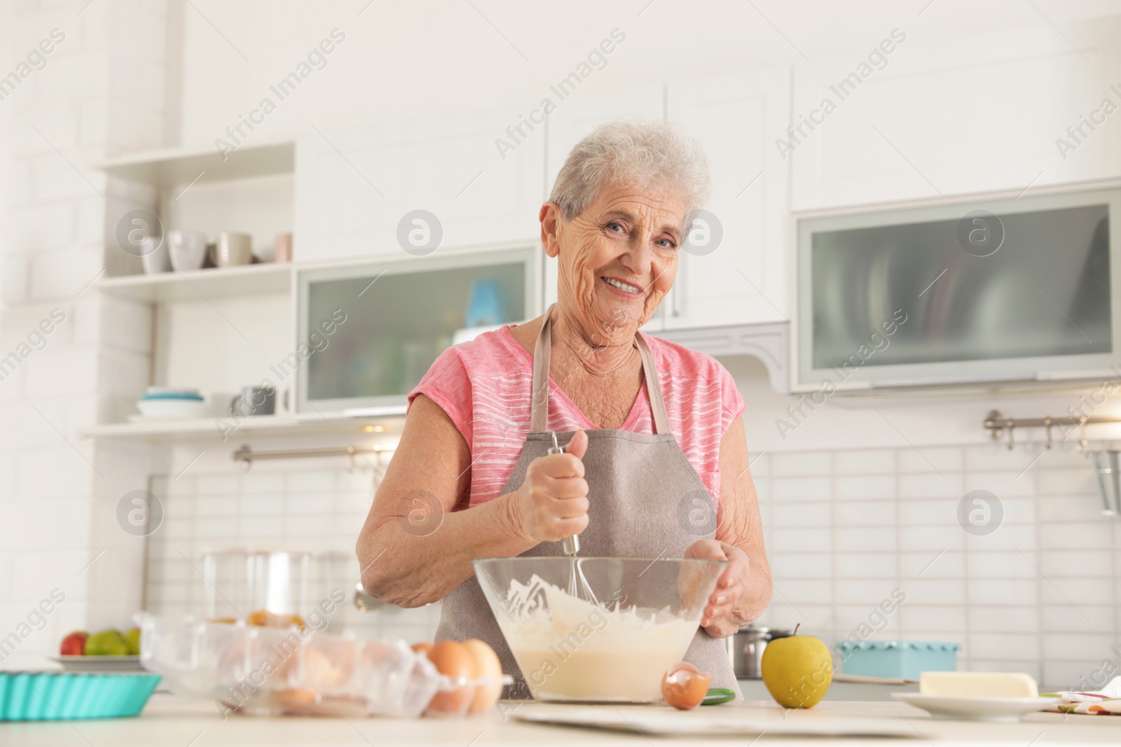 Photo of Portrait of beautiful grandmother cooking in kitchen