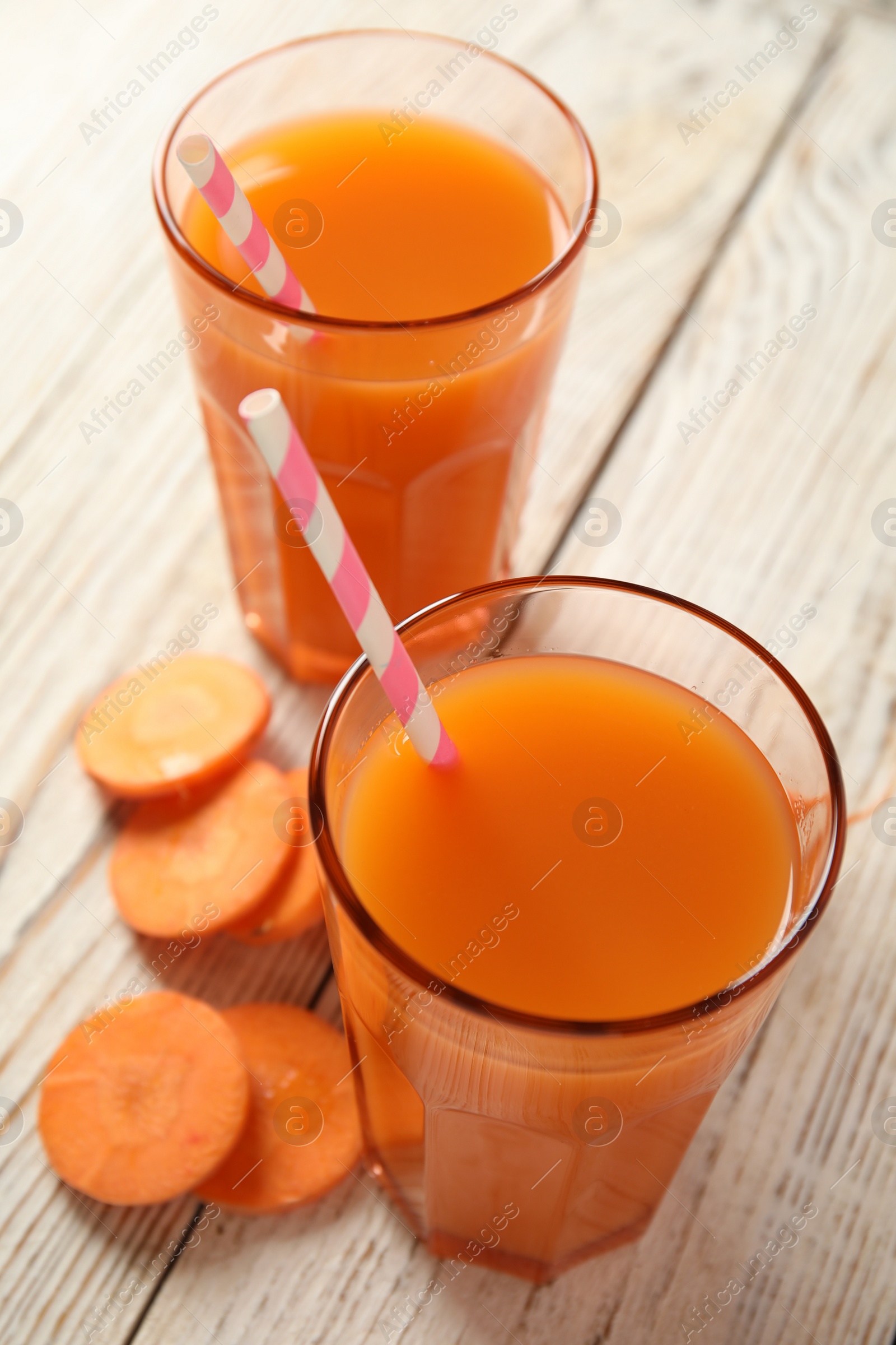 Photo of Freshly made carrot juice on wooden table