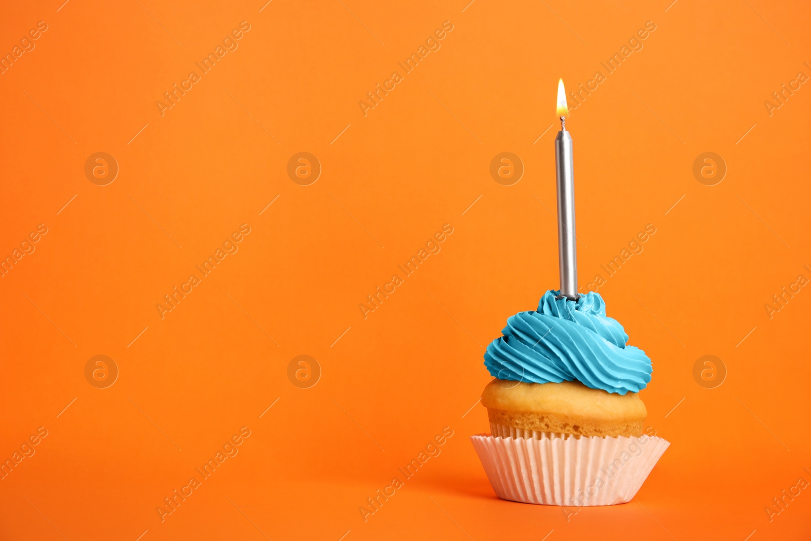 Photo of Birthday cupcake with candle on orange background, space for text