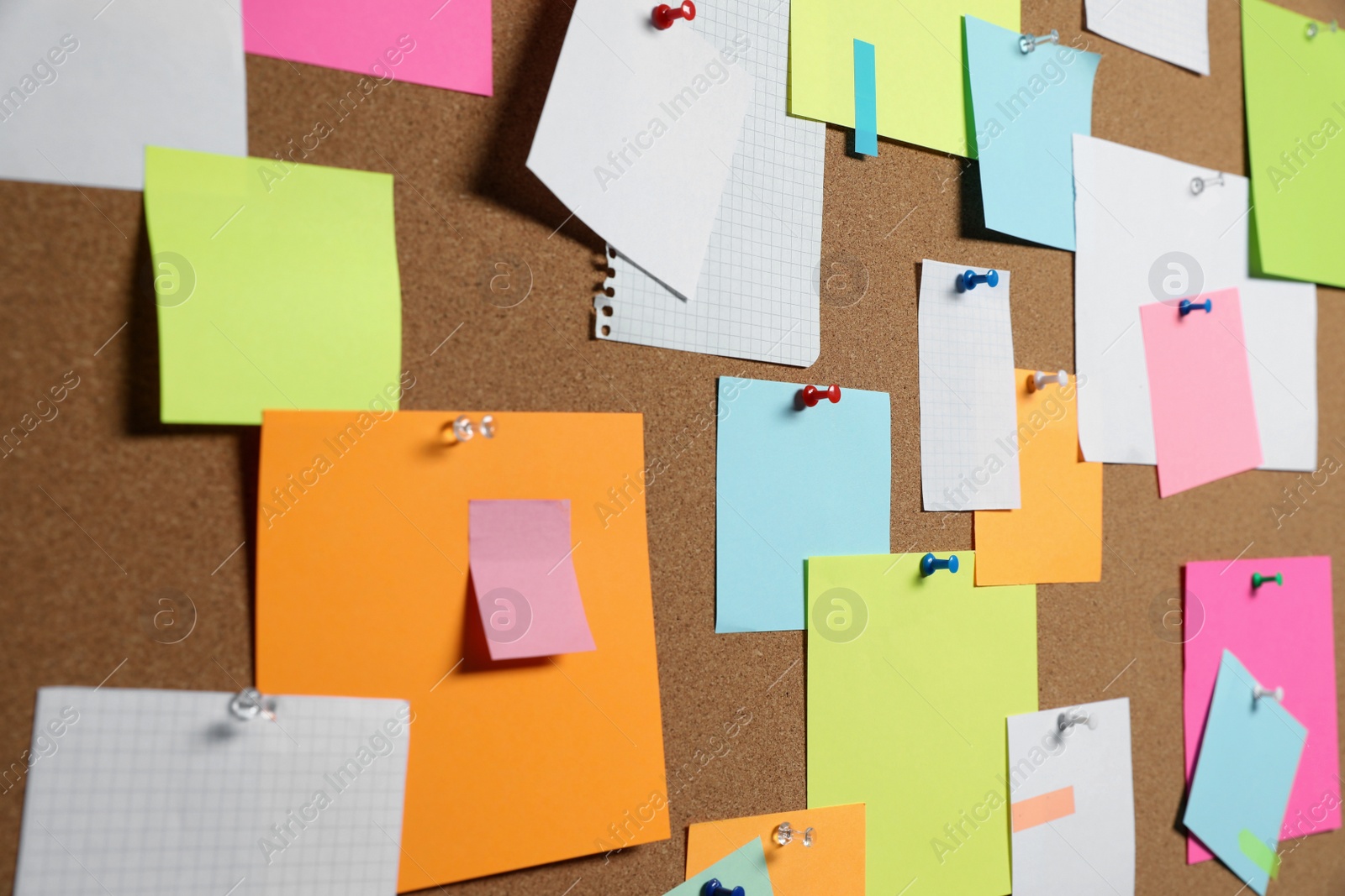 Photo of Many colorful notes pinned to cork board, closeup