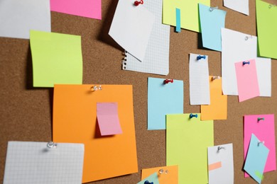 Many colorful notes pinned to cork board, closeup