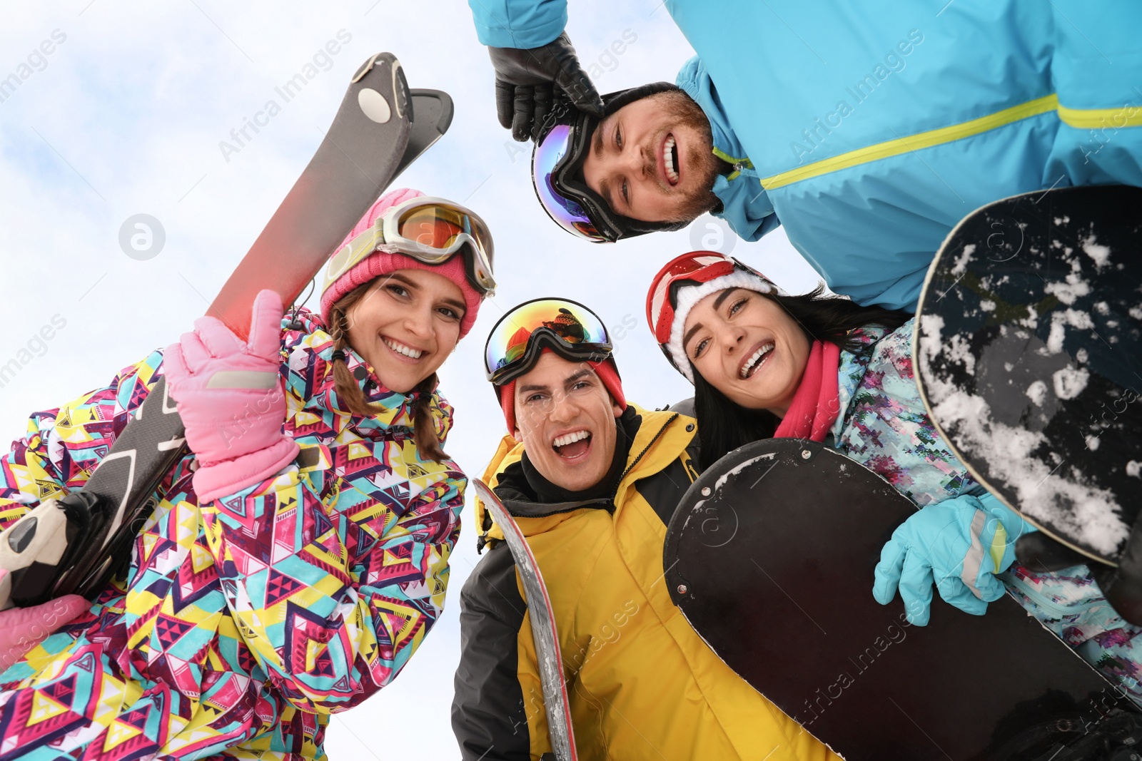 Photo of Group of friends joined in circle outdoors, bottom view. Winter vacation