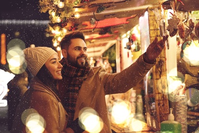 Image of Lovely couple spending time together at Christmas fair