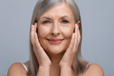 Portrait of beautiful senior woman on grey background