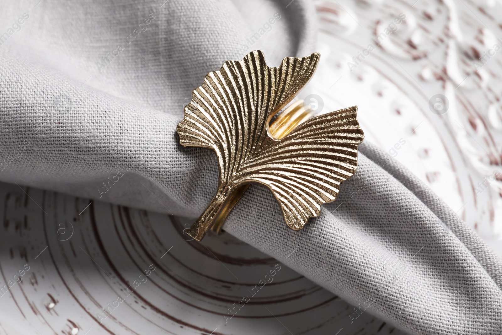 Photo of Fabric napkin and decorative ring on plate, closeup