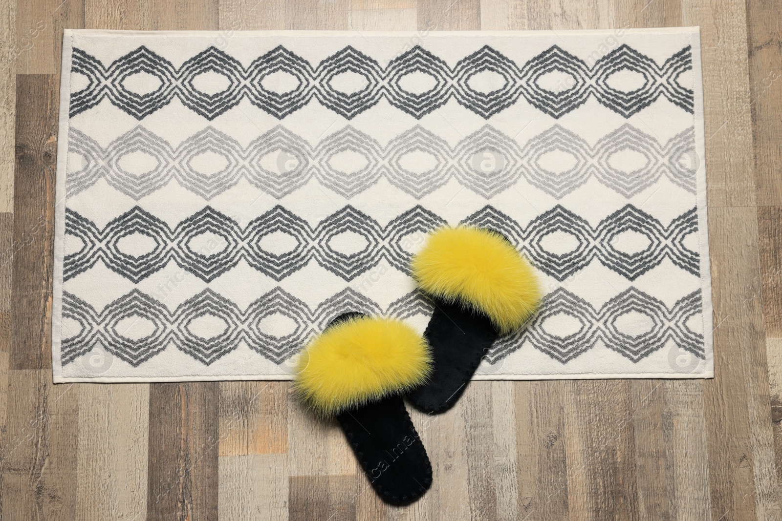 Photo of Soft bath mat and slippers on floor, top view