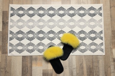 Soft bath mat and slippers on floor, top view