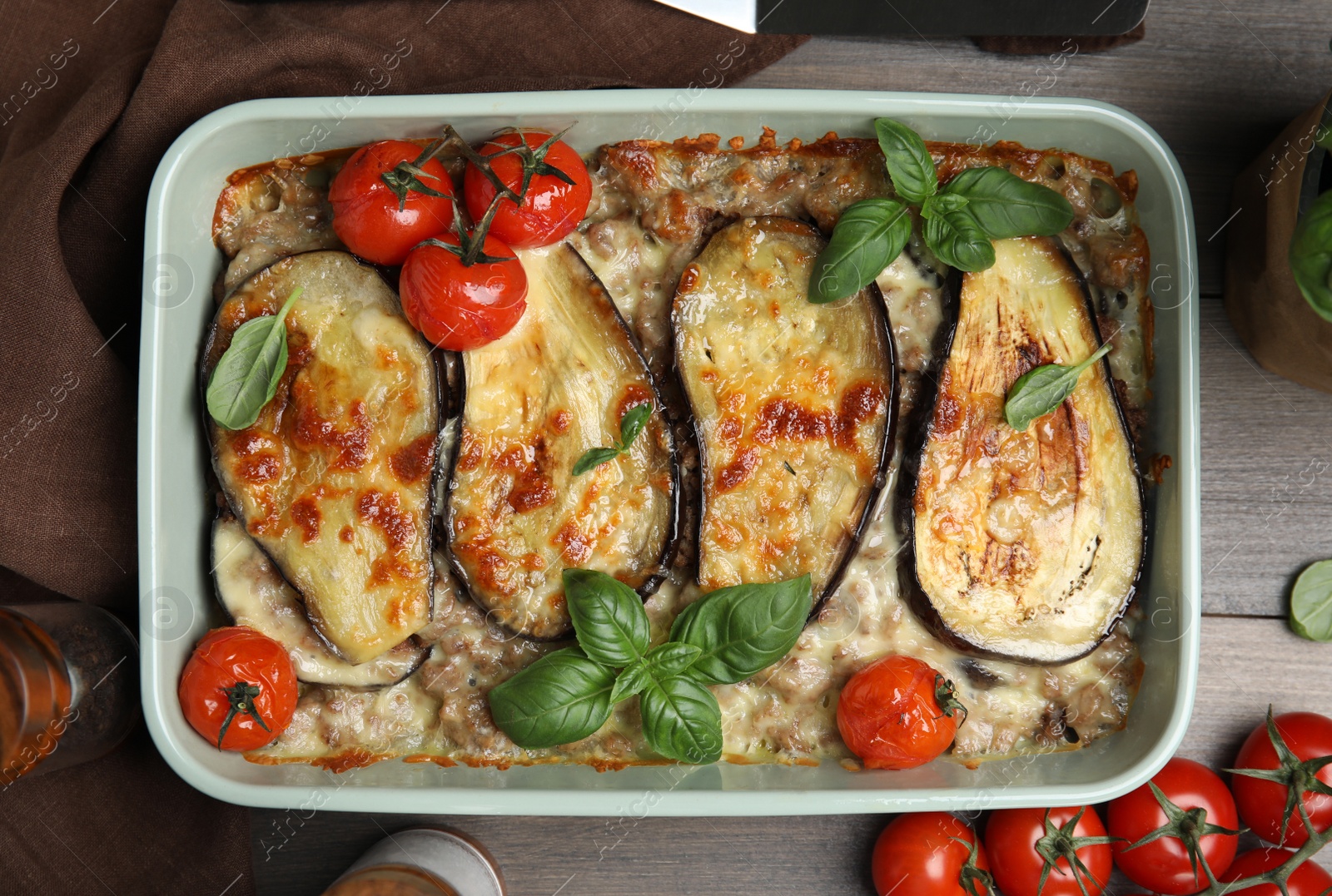 Photo of Delicious eggplant lasagna in baking dish on wooden table, flat lay