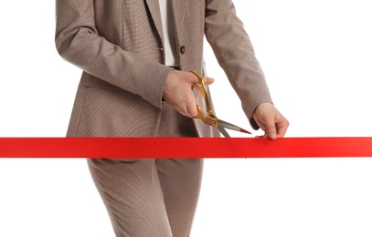 Woman in office suit cutting red ribbon isolated on white, closeup