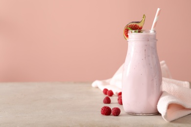 Photo of Delicious fig smoothie in bottle on light table, space for text