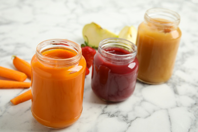 Photo of Healthy baby food in jars and fresh ingredients on white marble table