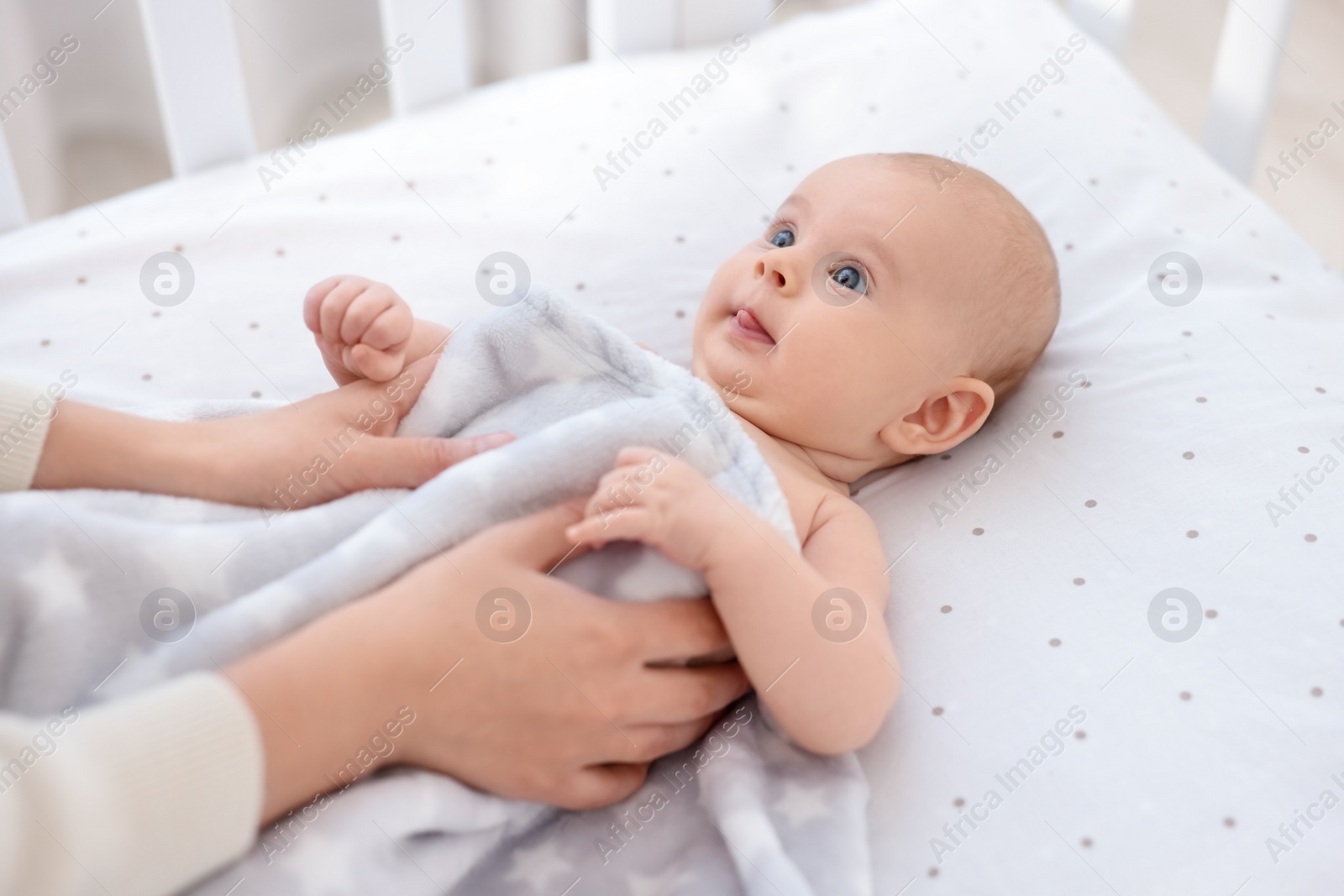 Photo of Mother with her cute little baby in crib