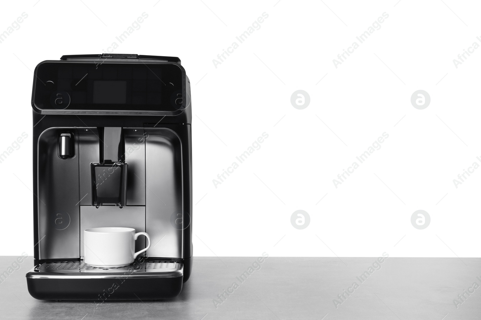 Photo of Modern electric coffee machine with cup on table against white background. Space for text