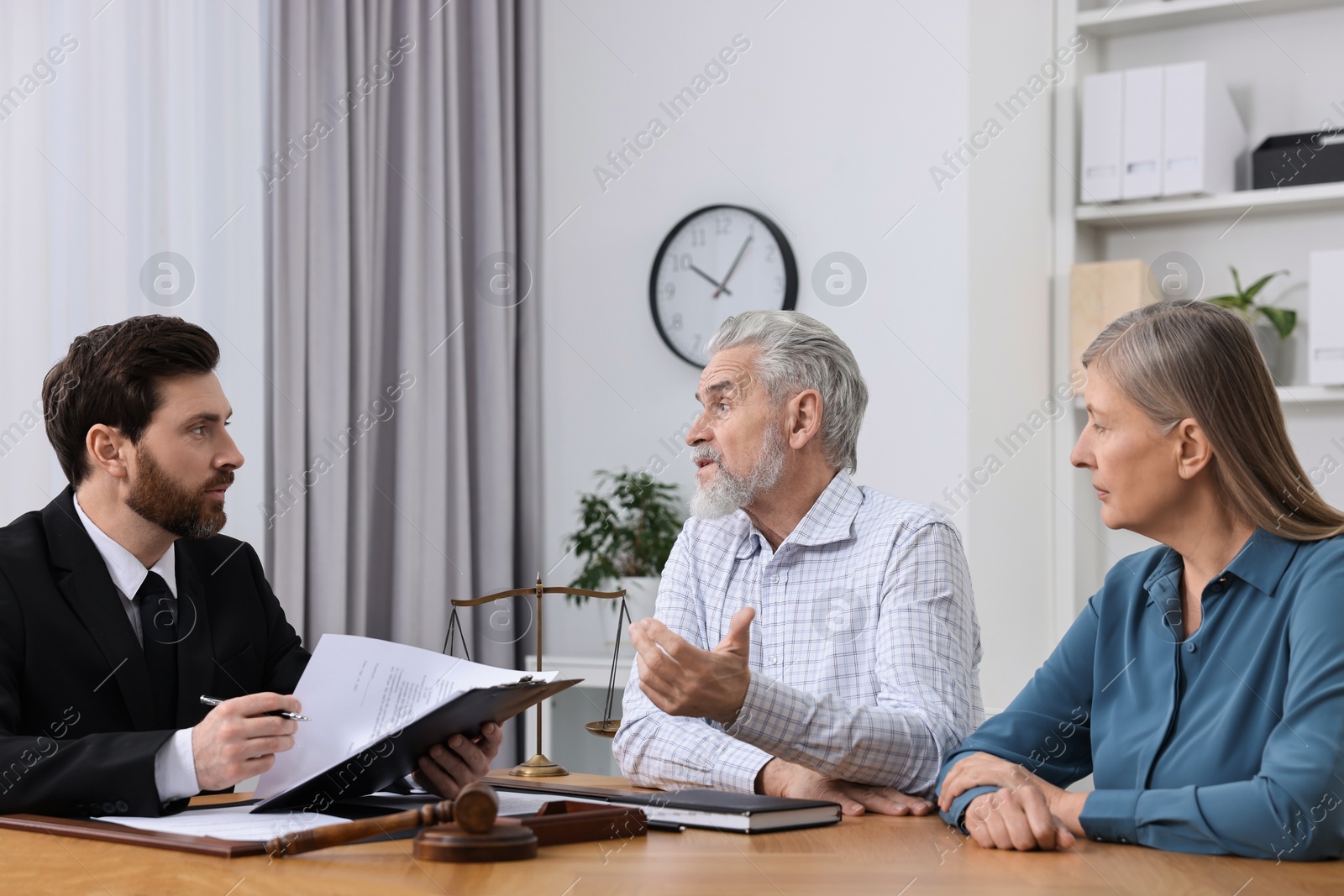 Photo of Senior couple having meeting with lawyer in office