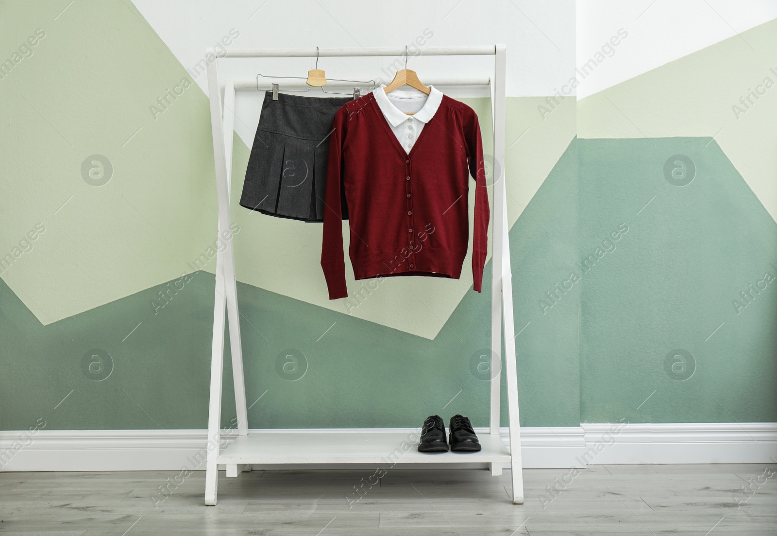 Photo of School uniform for girl on rack near color wall