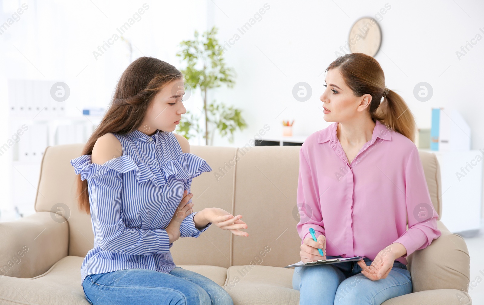 Photo of Female psychologist working with teenager girl in office