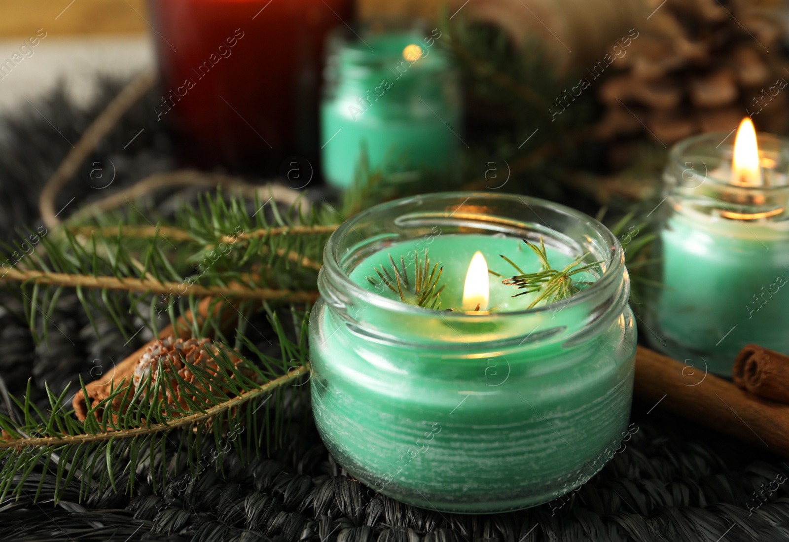 Photo of Burning scented conifer candles and Christmas decor on table