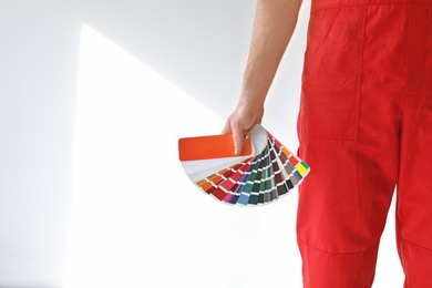 Photo of Male decorator with color palette on white background, closeup