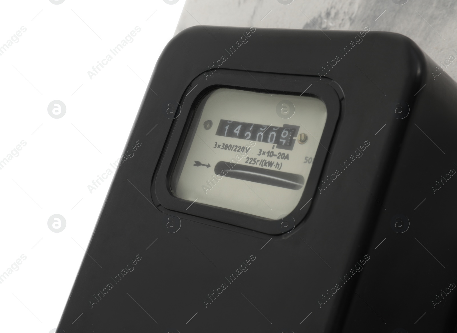 Photo of Electricity meter on light grey wall against white background, closeup. Space for text