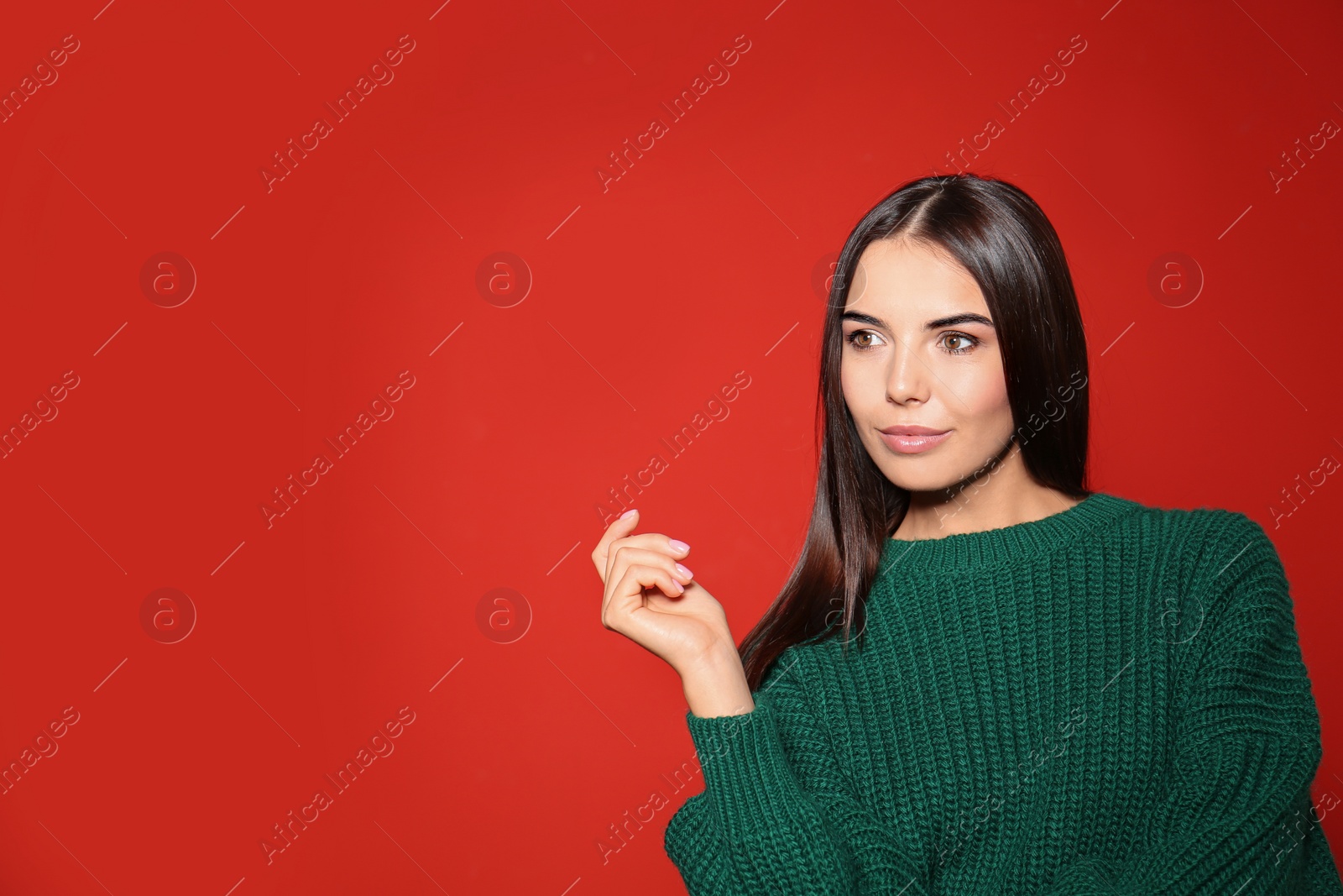 Image of Pretty woman wearing warm sweater on red background. Space for text