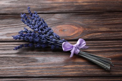Photo of Bouquet of beautiful preserved lavender flowers on wooden table