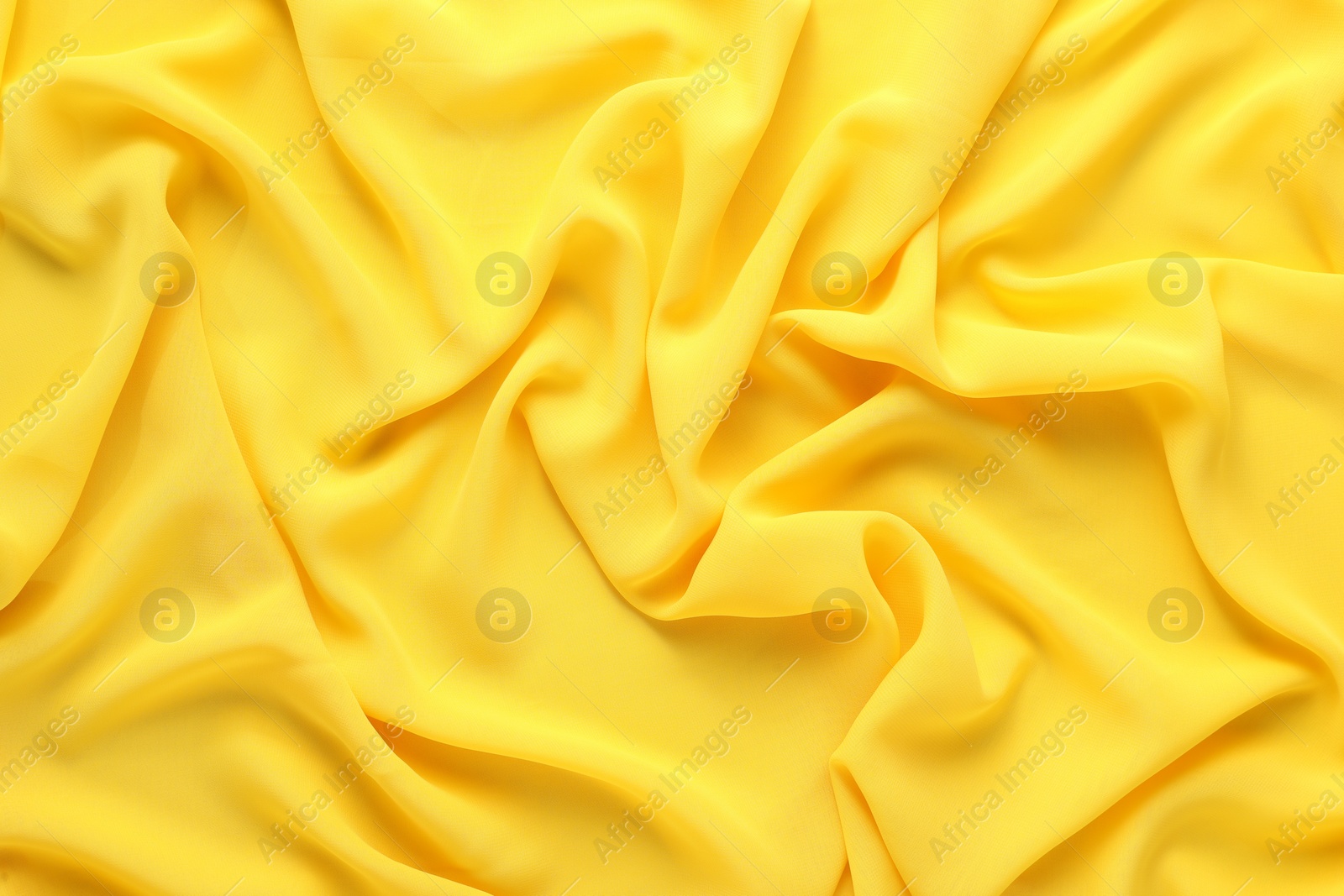 Photo of Beautiful yellow tulle fabric as background, top view