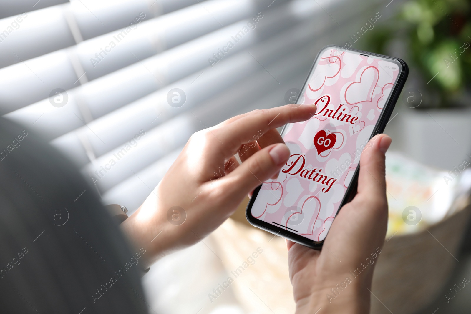 Image of Woman visiting dating site via smartphone indoors, closeup