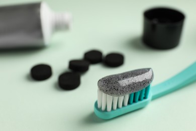Photo of Brush with charcoal toothpaste on white background, closeup