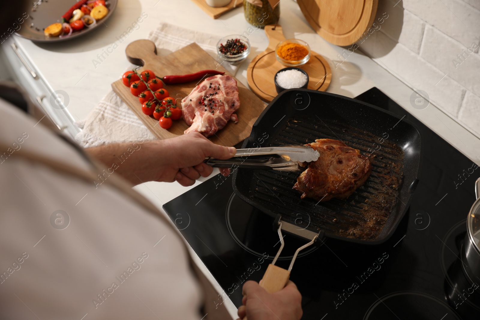 Photo of Man taking cooked meat from frying pan, above view