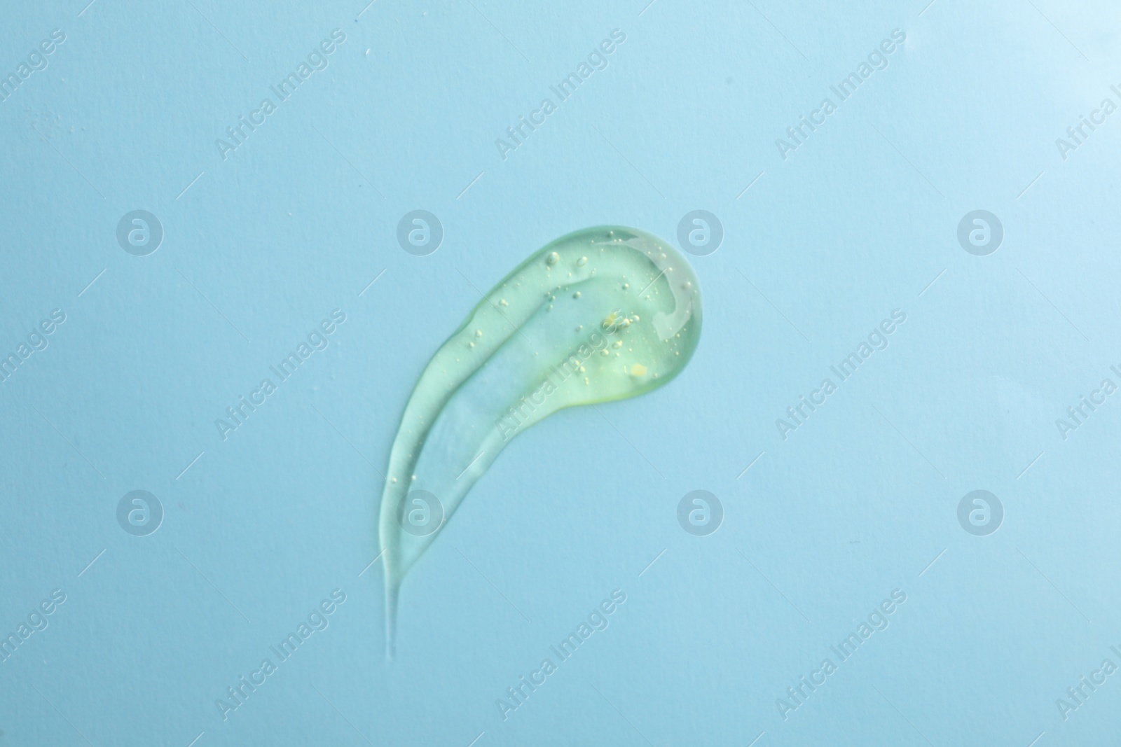 Photo of Smear of ointment on light blue background, top view