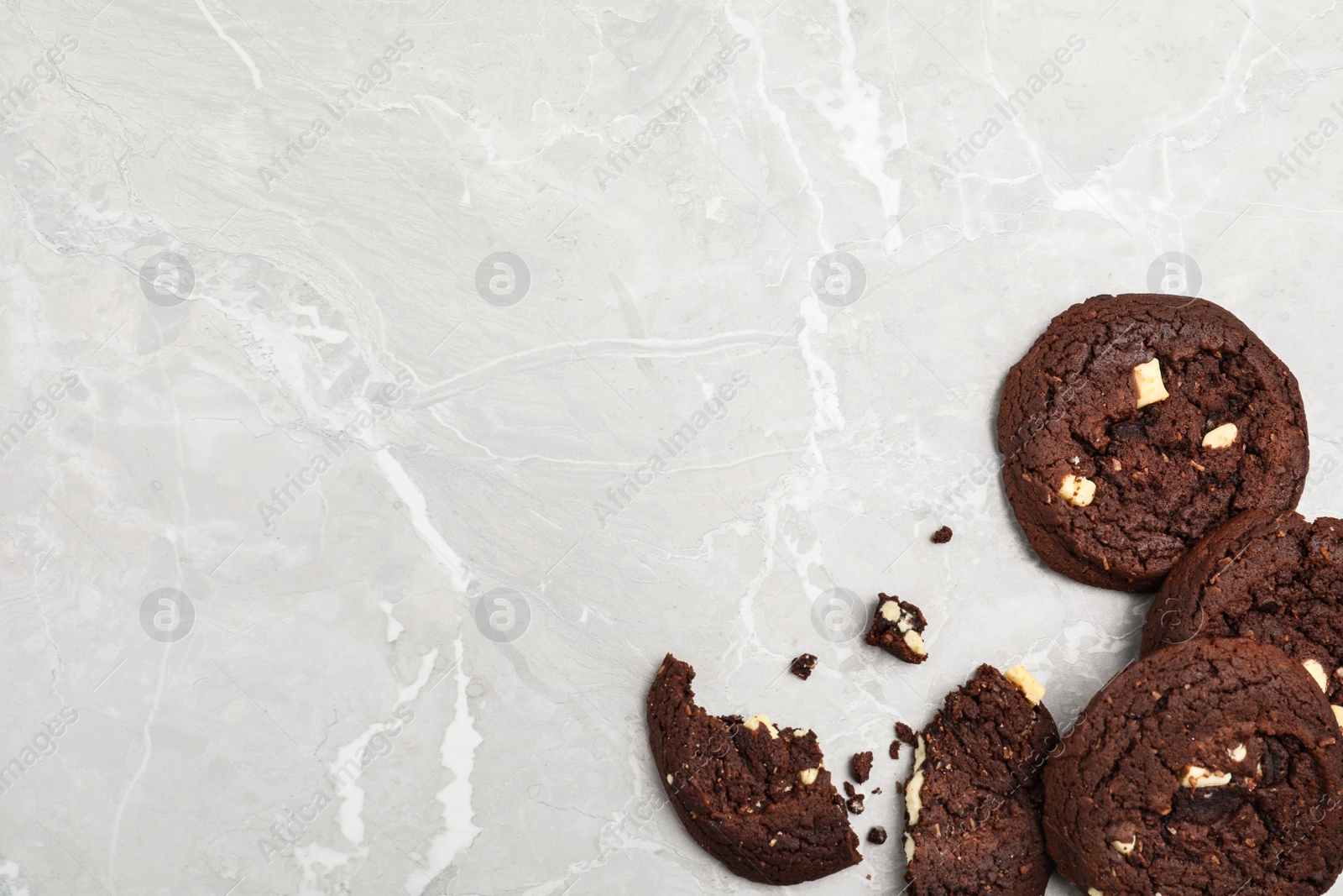 Photo of Delicious chocolate cookies on marble table, flat lay. Space for text