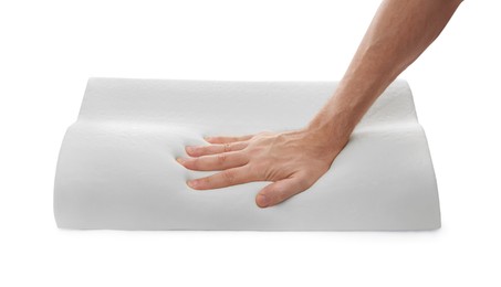 Man touching orthopedic memory foam pillow on white background, closeup